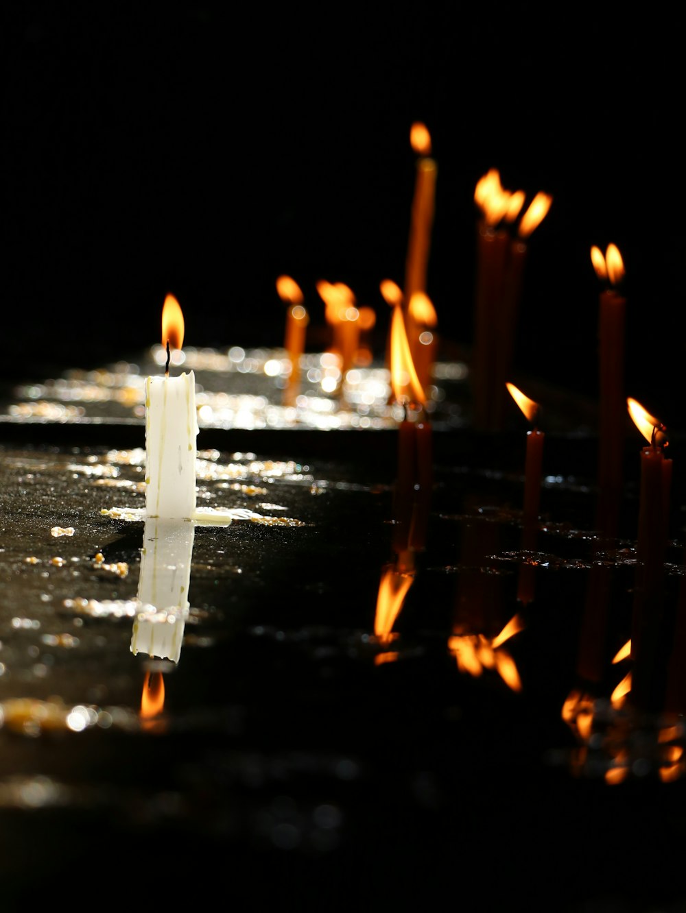 a row of lit candles sitting on top of a table