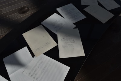 a table topped with lots of papers on top of a wooden floor