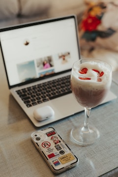 A laptop screen showing the her unmuted podcast website with pastel pink and yellow gradient background.