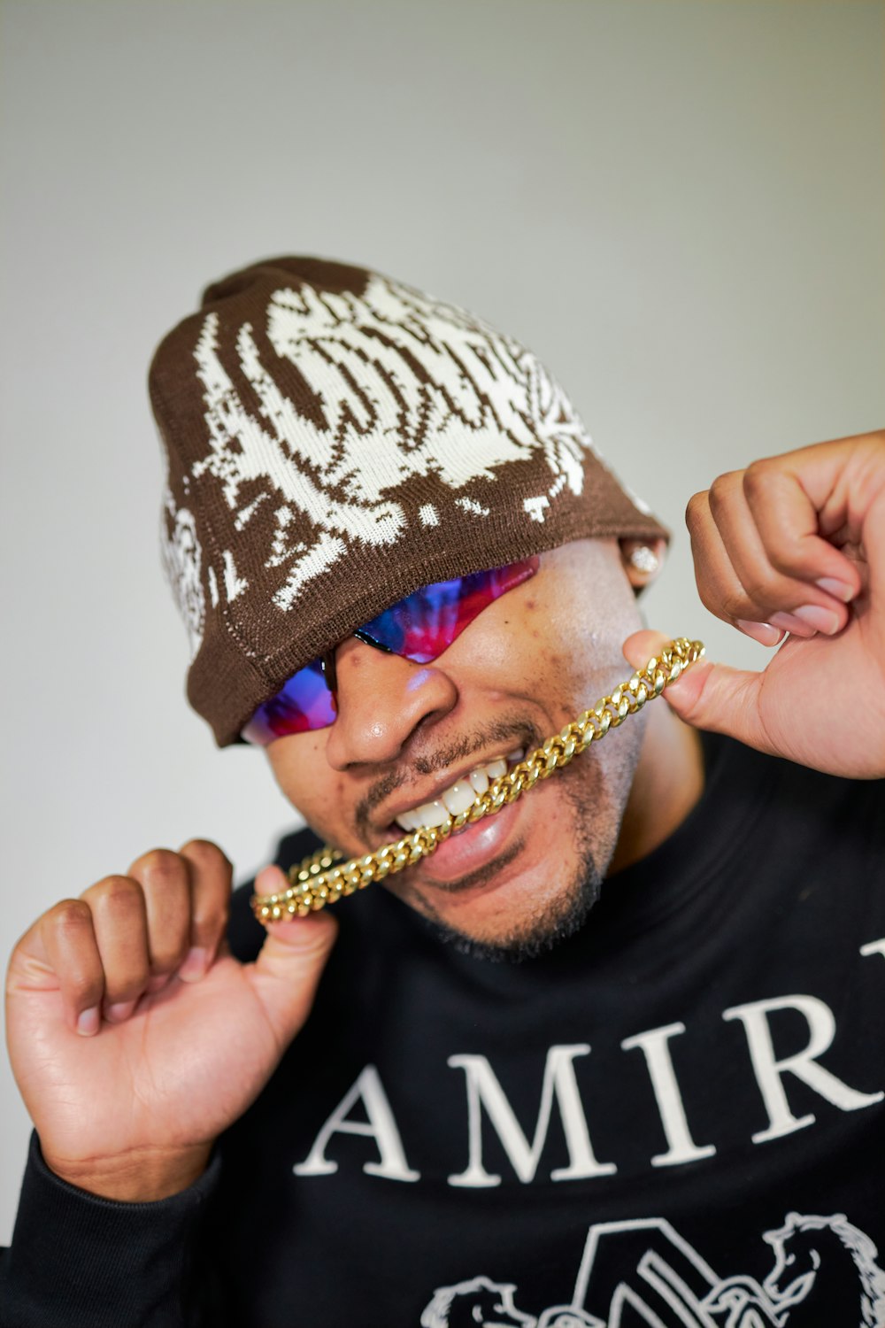 a man wearing a beanie and a chain around his neck