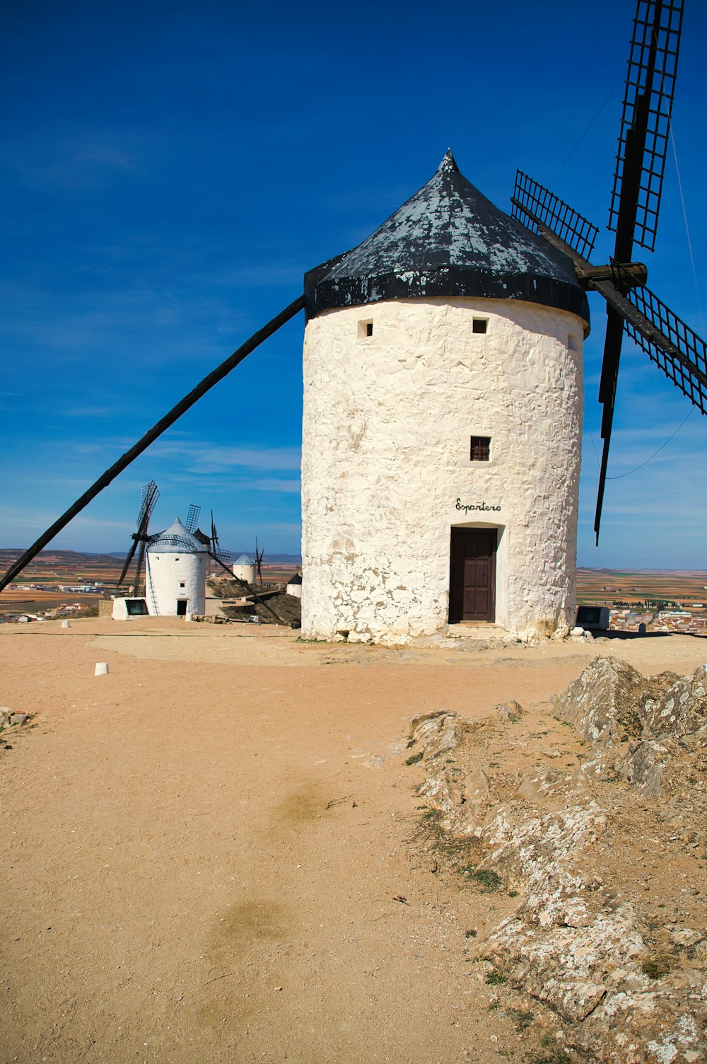 a white windmill sitting on top of a dirt field