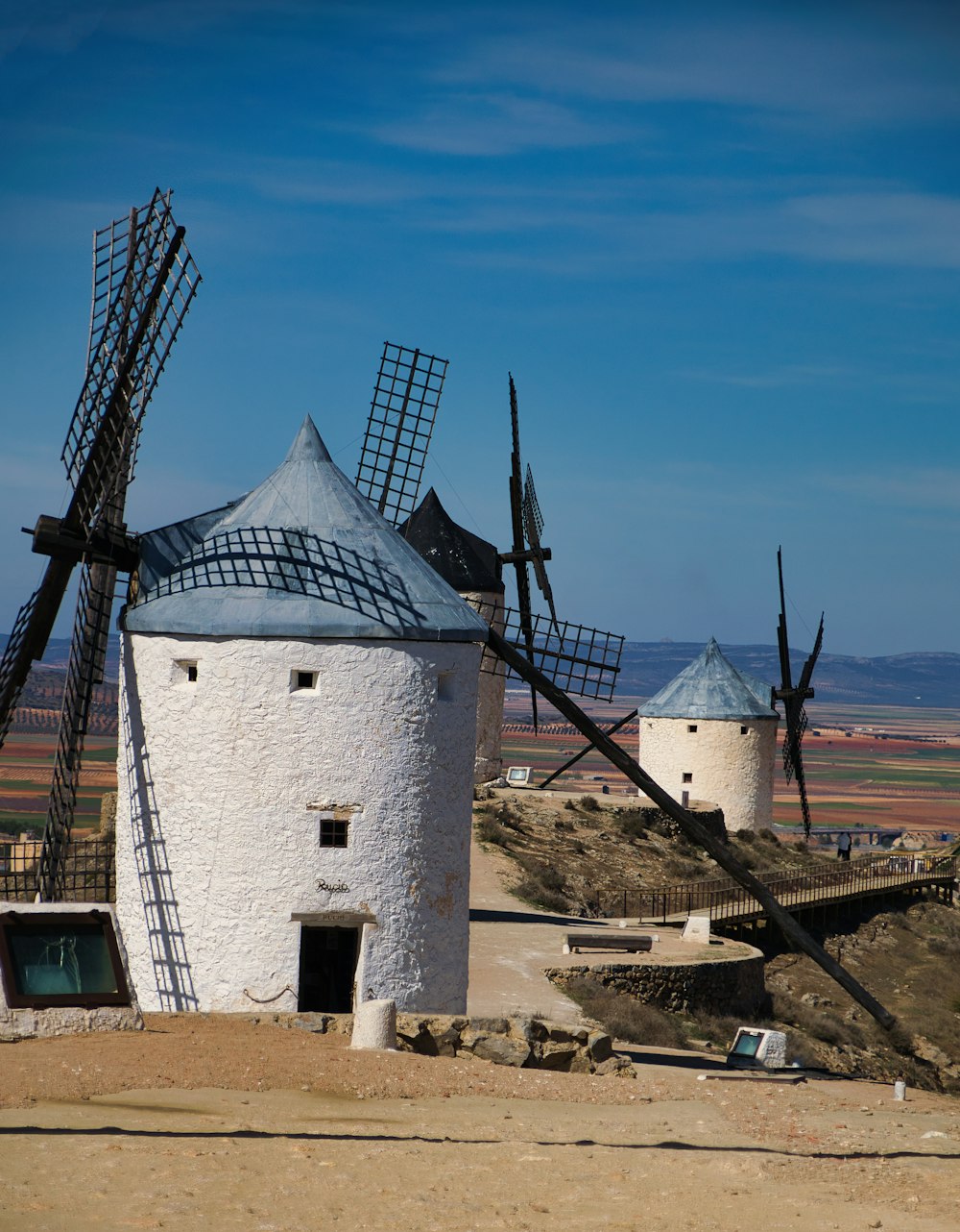 um velho moinho de vento fica no meio de um deserto