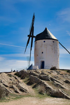 a windmill on top of a hill with a sky background