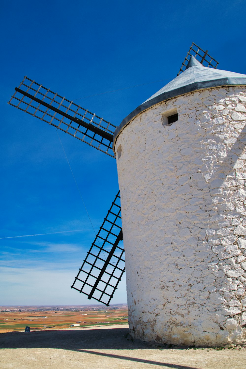 a white windmill with a blue sky in the background