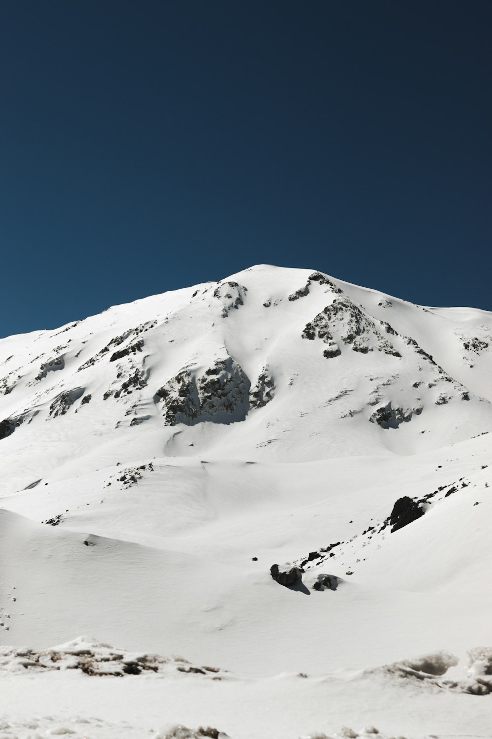 a mountain covered in snow under a blue sky