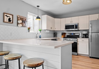 a kitchen with three stools and a center island