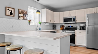 a kitchen with three stools and a center island