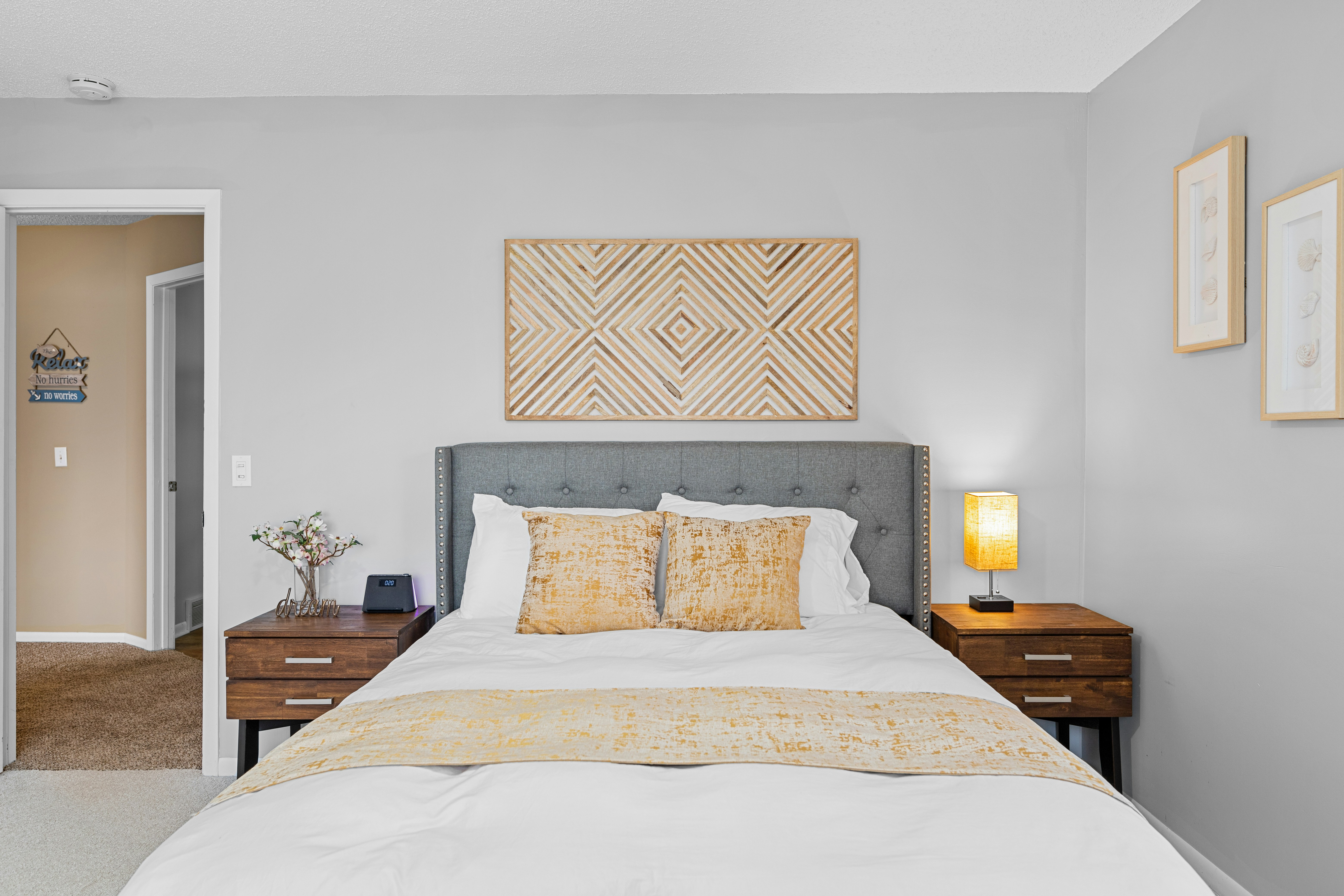 a bedroom with a neatly made bed and a painting on the wall
