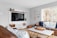 A modern living room with a wall-mounted TV and stylish decor.