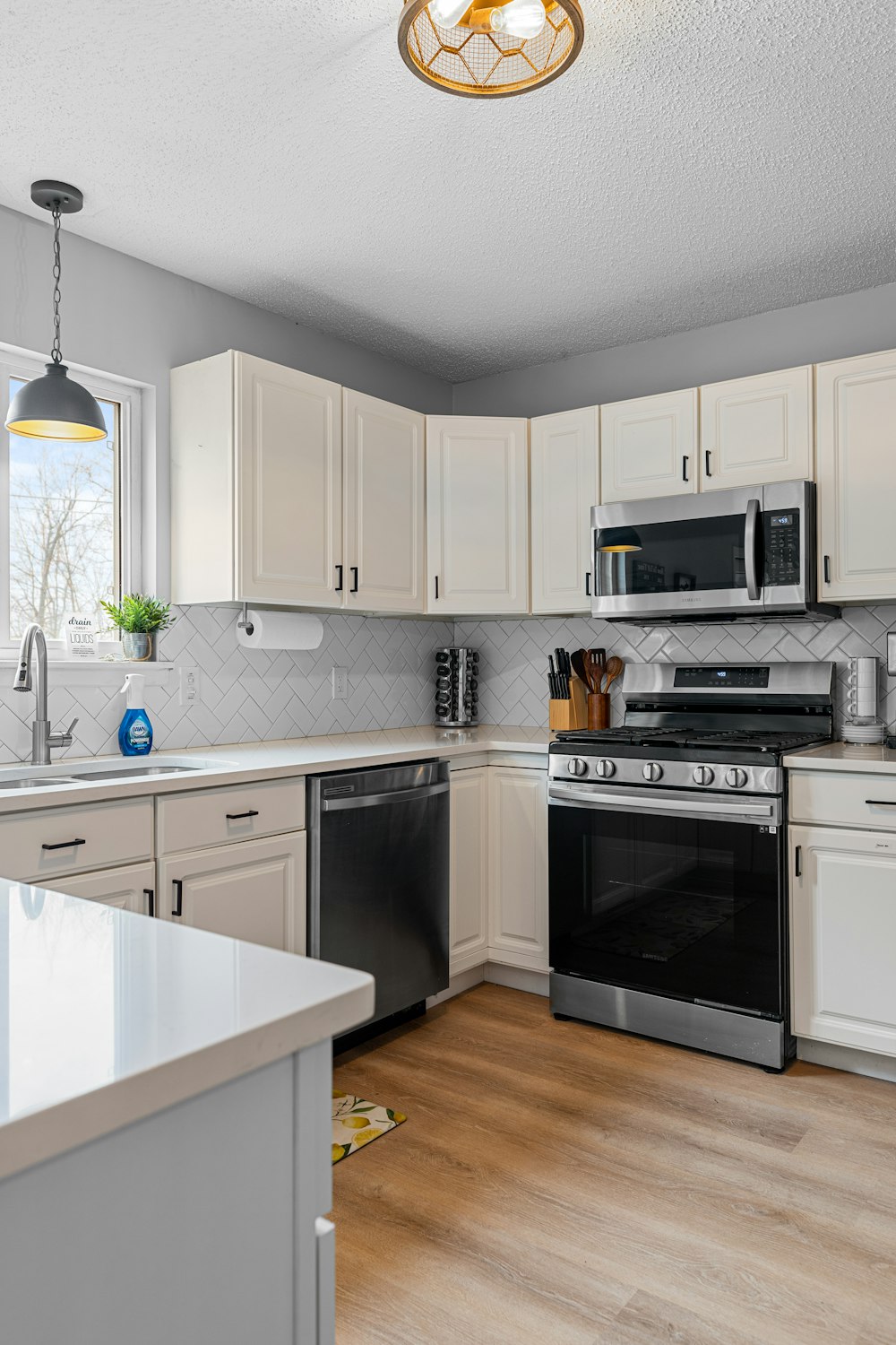 a kitchen with white cabinets and stainless steel appliances