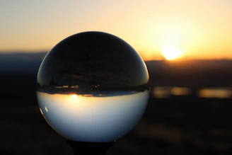 a glass ball sitting on top of a metal pole
