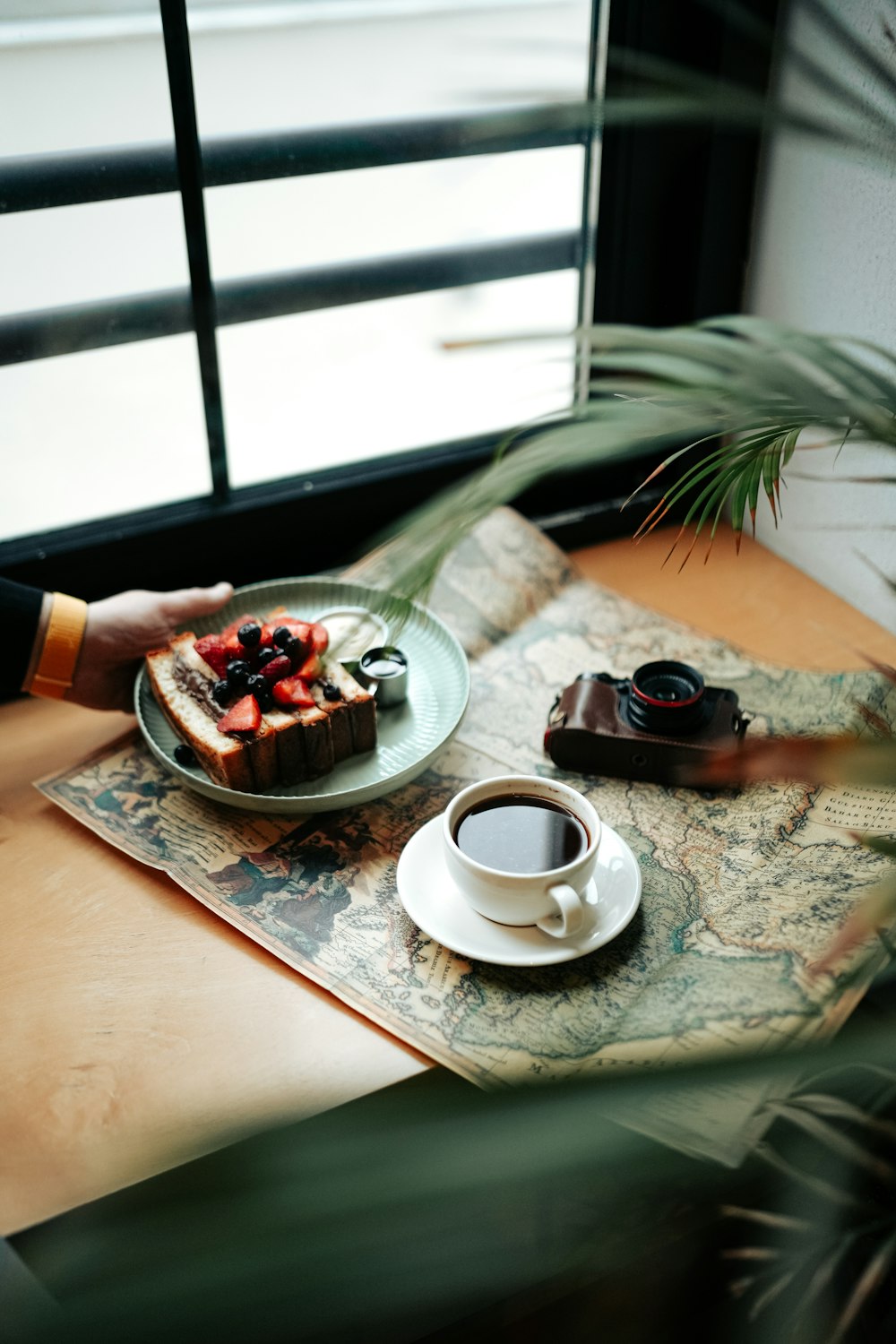 une table avec une assiette de nourriture et une tasse de café