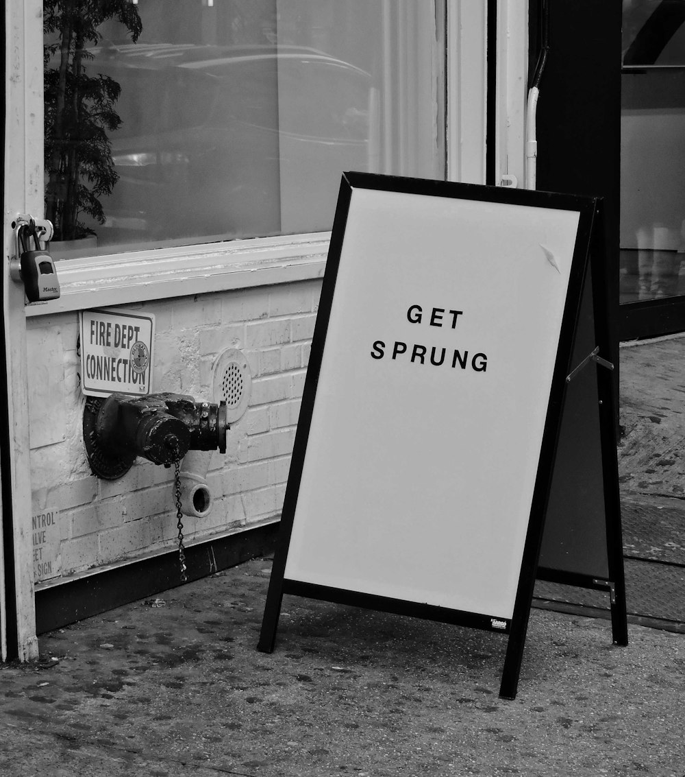 a black and white photo of a sign in front of a store