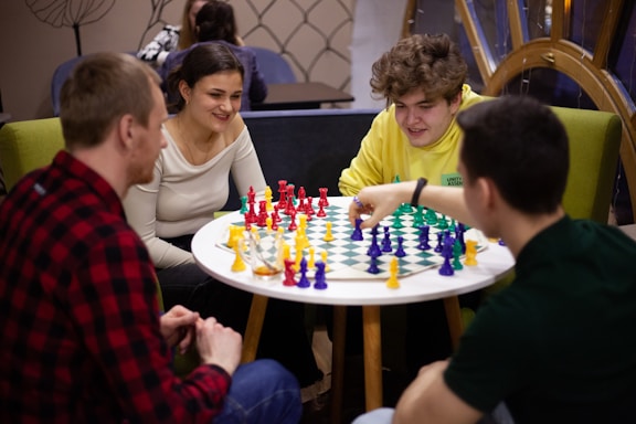 A friendly instructor teaching a group of kids chess in a bright, colorful classroom.