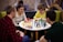 A group of diverse individuals engaged in an intense chess match at a community center.