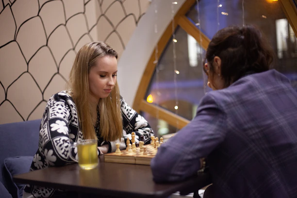 An elderly woman smiling while playing chess in a cozy living room setting.