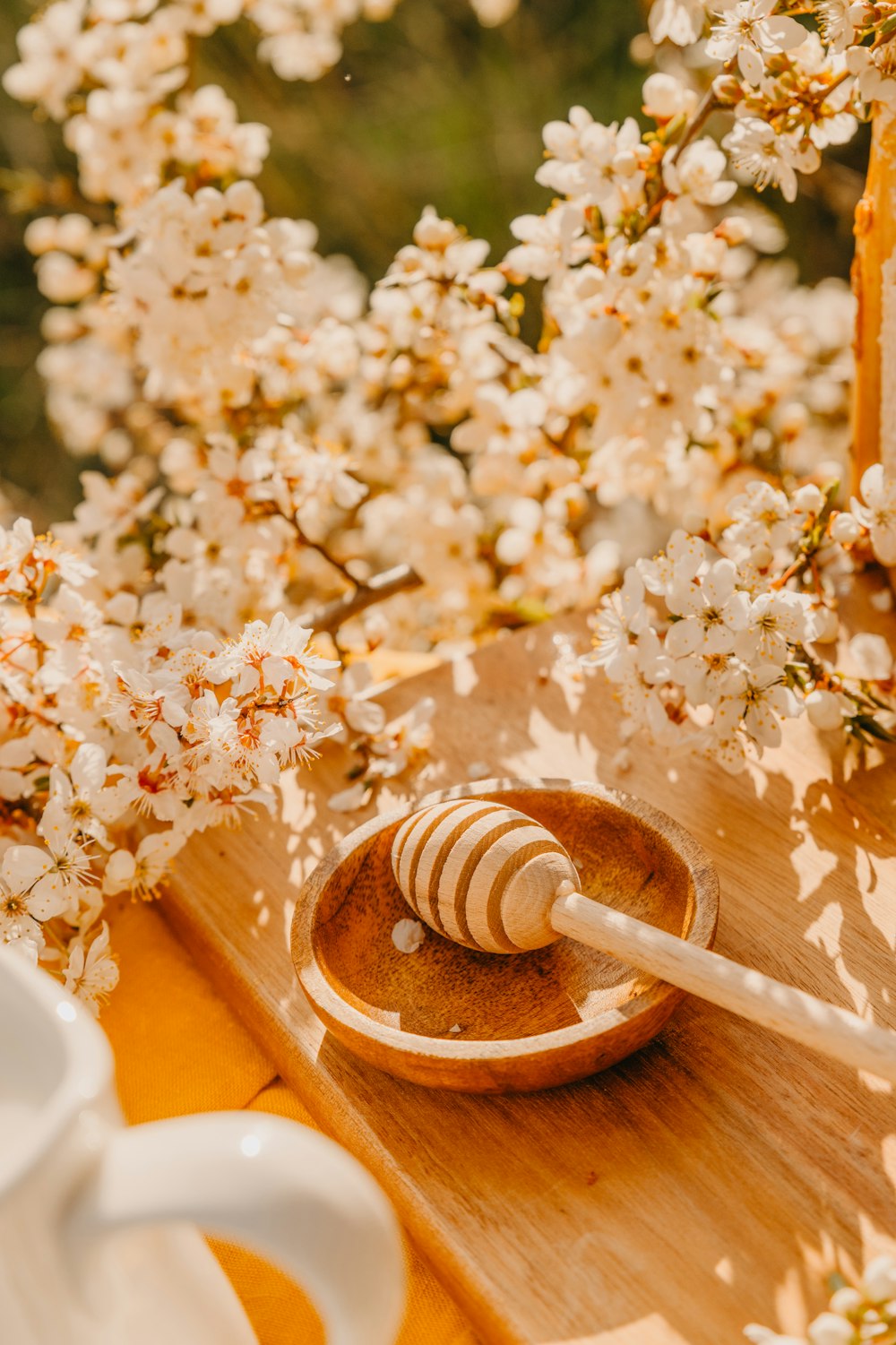 a honey dipper sitting on top of a wooden tray