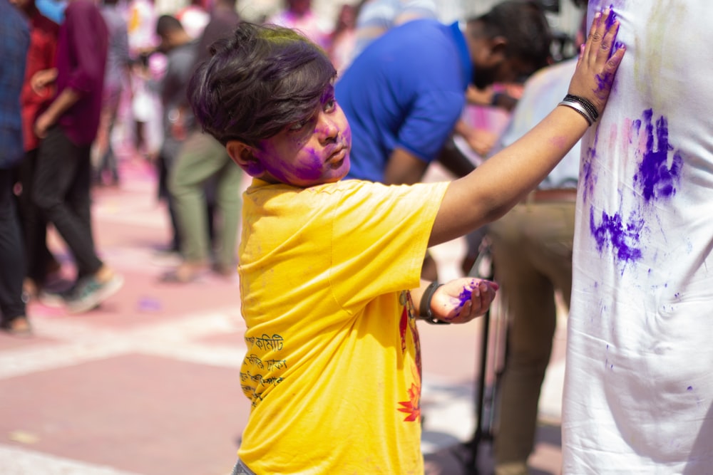 a young boy with purple paint on his face