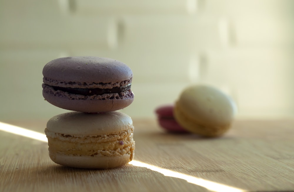 a stack of three macaroons sitting on top of a wooden table