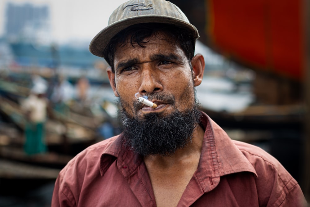 Un homme avec une barbe fume une cigarette