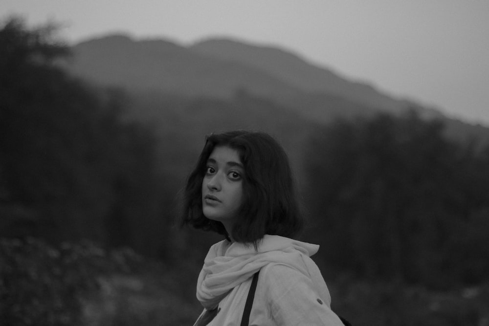 a black and white photo of a woman in a scarf