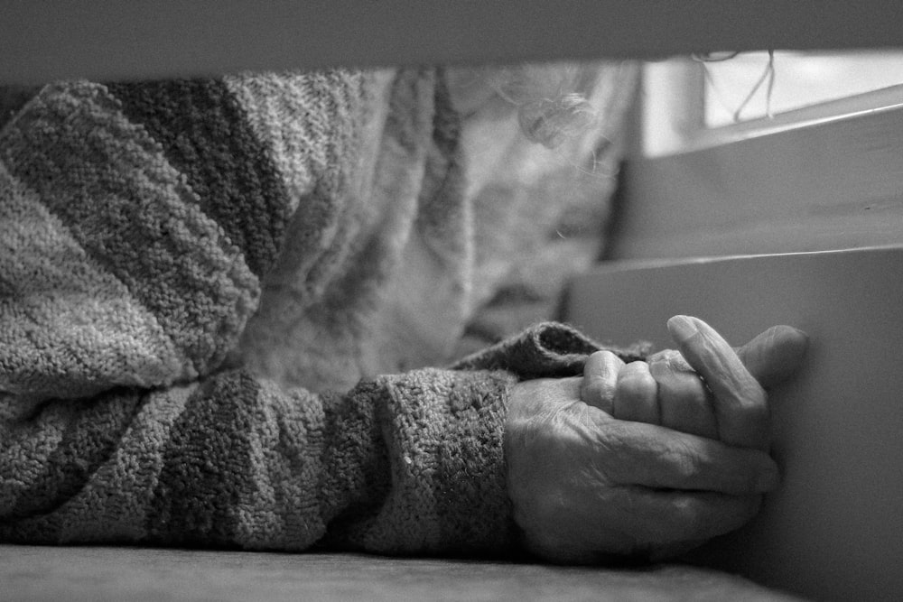 a person with their hands on the edge of a window sill