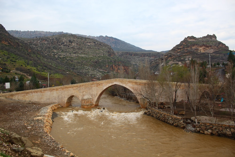 a bridge over a river with a mountain in the background