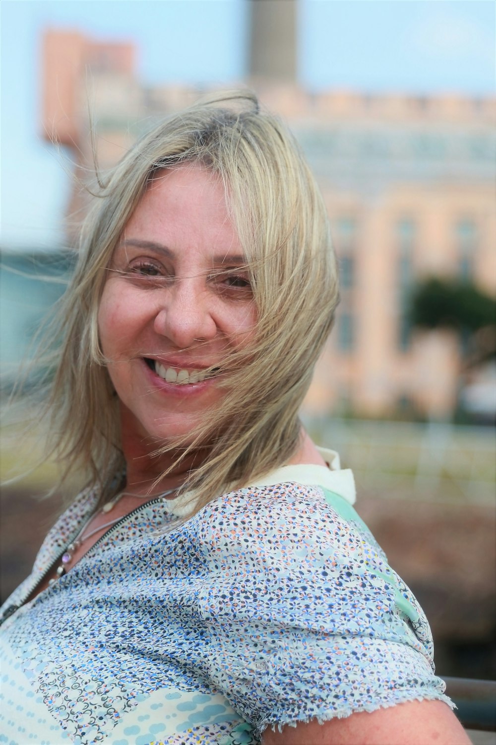 a woman with blonde hair smiling at the camera