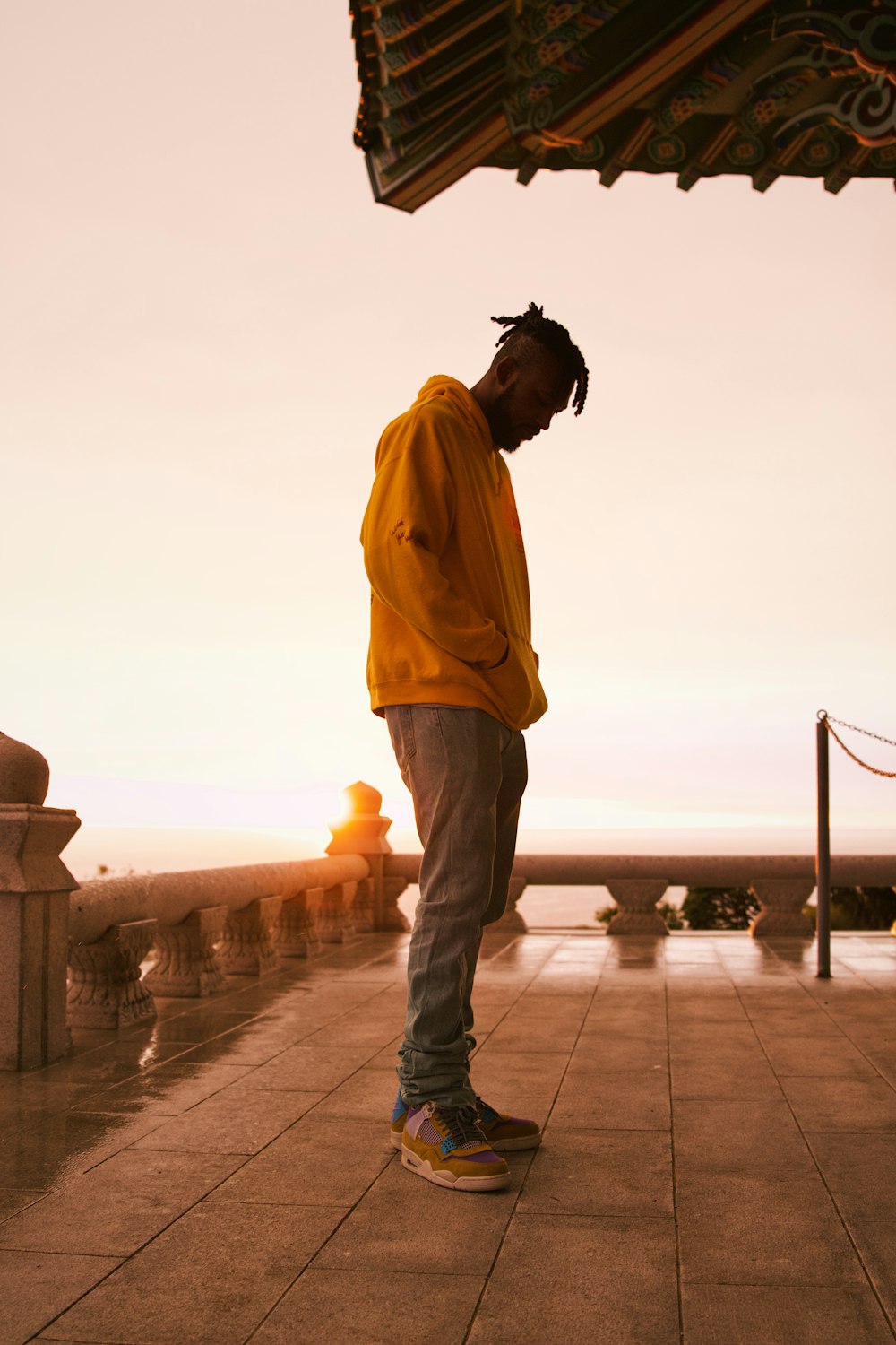 a man in a yellow jacket is standing on a sidewalk