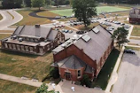 Wide shot of the academy facility in Greene County, NC, with trucks lined up and the driving track visible.