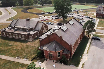 Wide shot of the academy facility in Greene County, NC, with trucks lined up and the driving track visible.