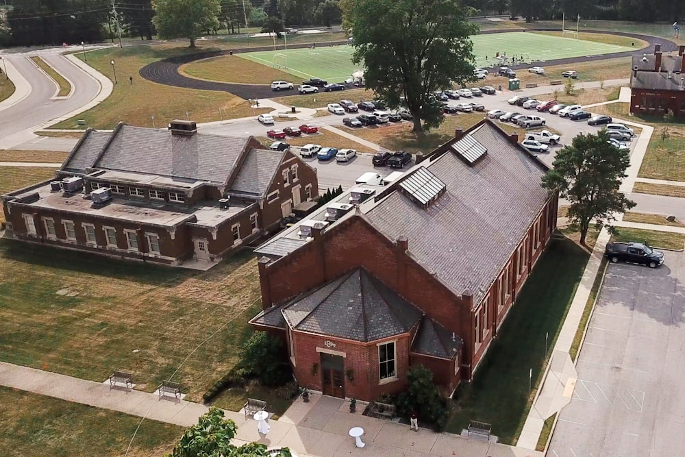 an aerial view of a building with cars parked in front of it