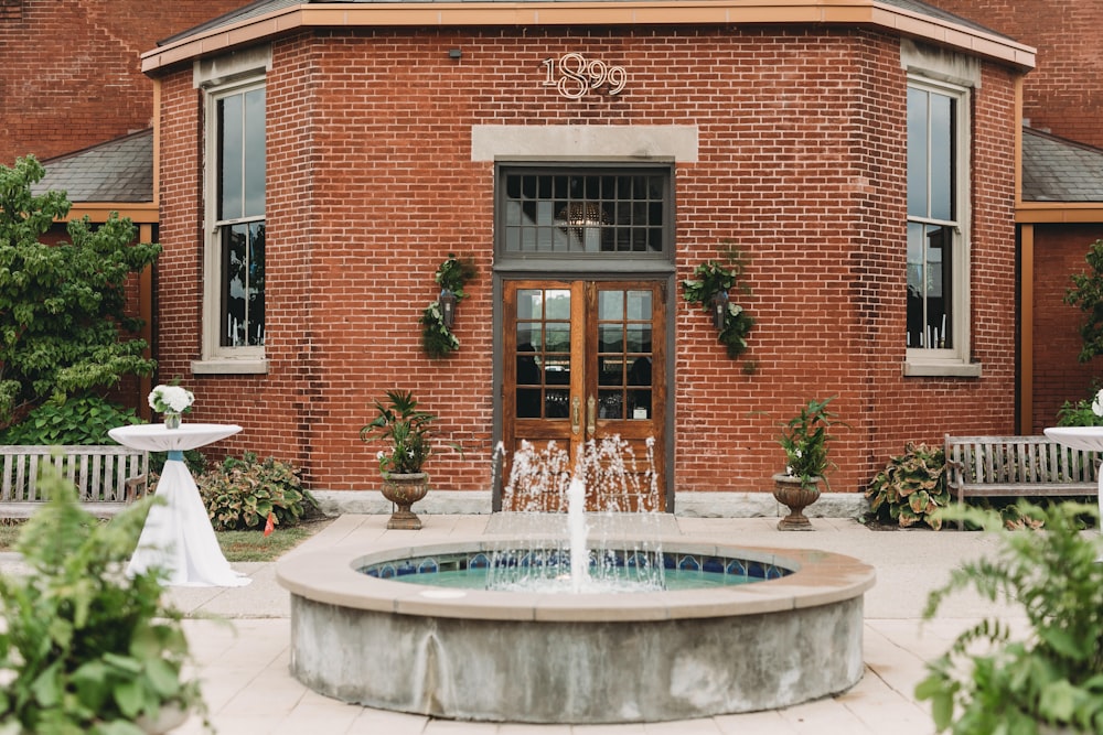 a brick building with a fountain in front of it