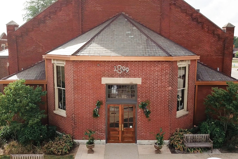 a red brick building with a bench in front of it