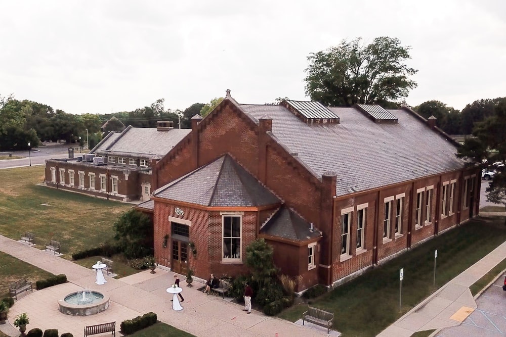 a large brick building with a fountain in front of it