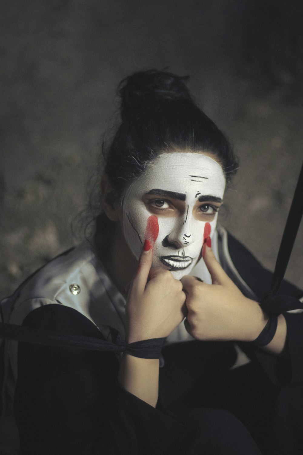 Una mujer con la cara pintada sosteniendo un paraguas