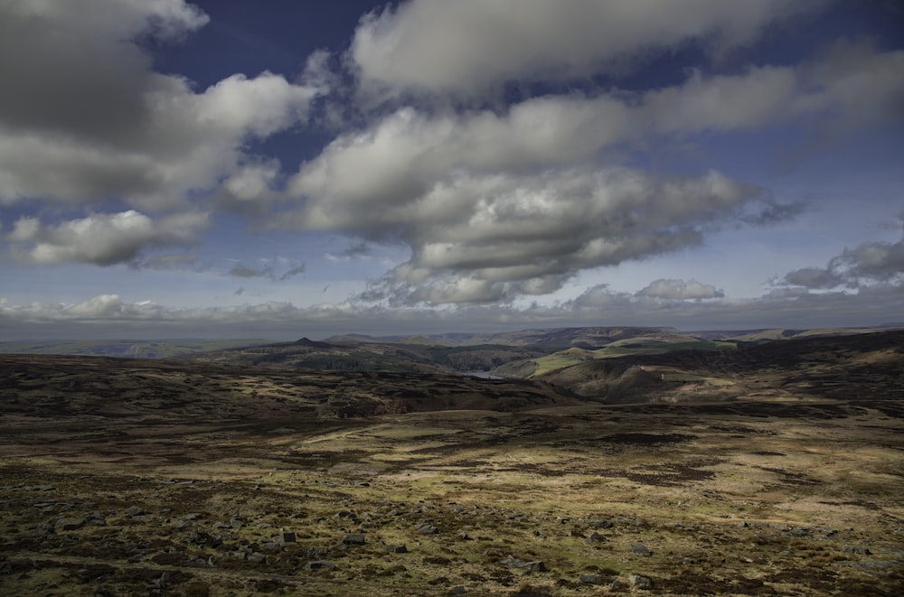 a view of some hills and clouds in the sky