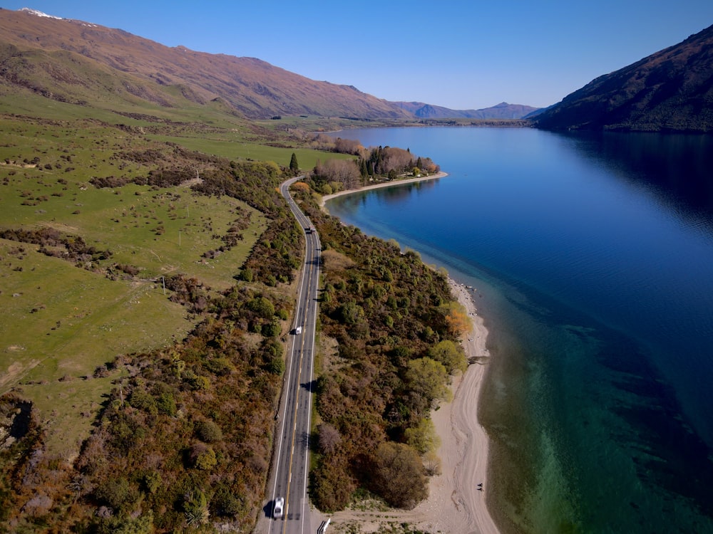 an aerial view of a road next to a body of water