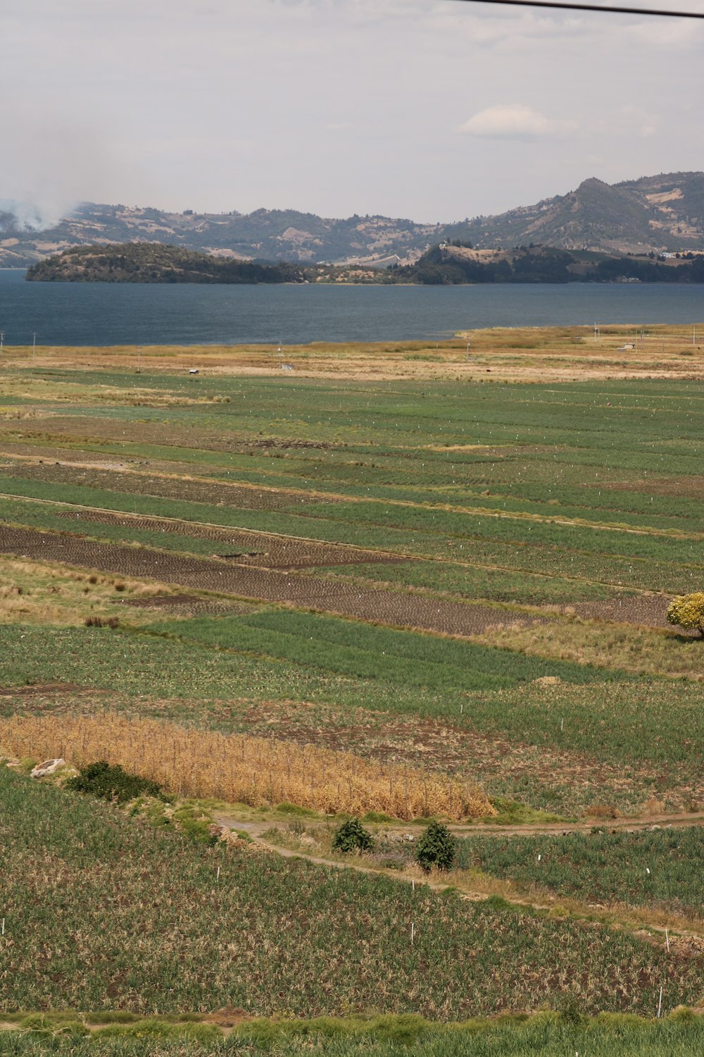 a large field with a body of water in the distance