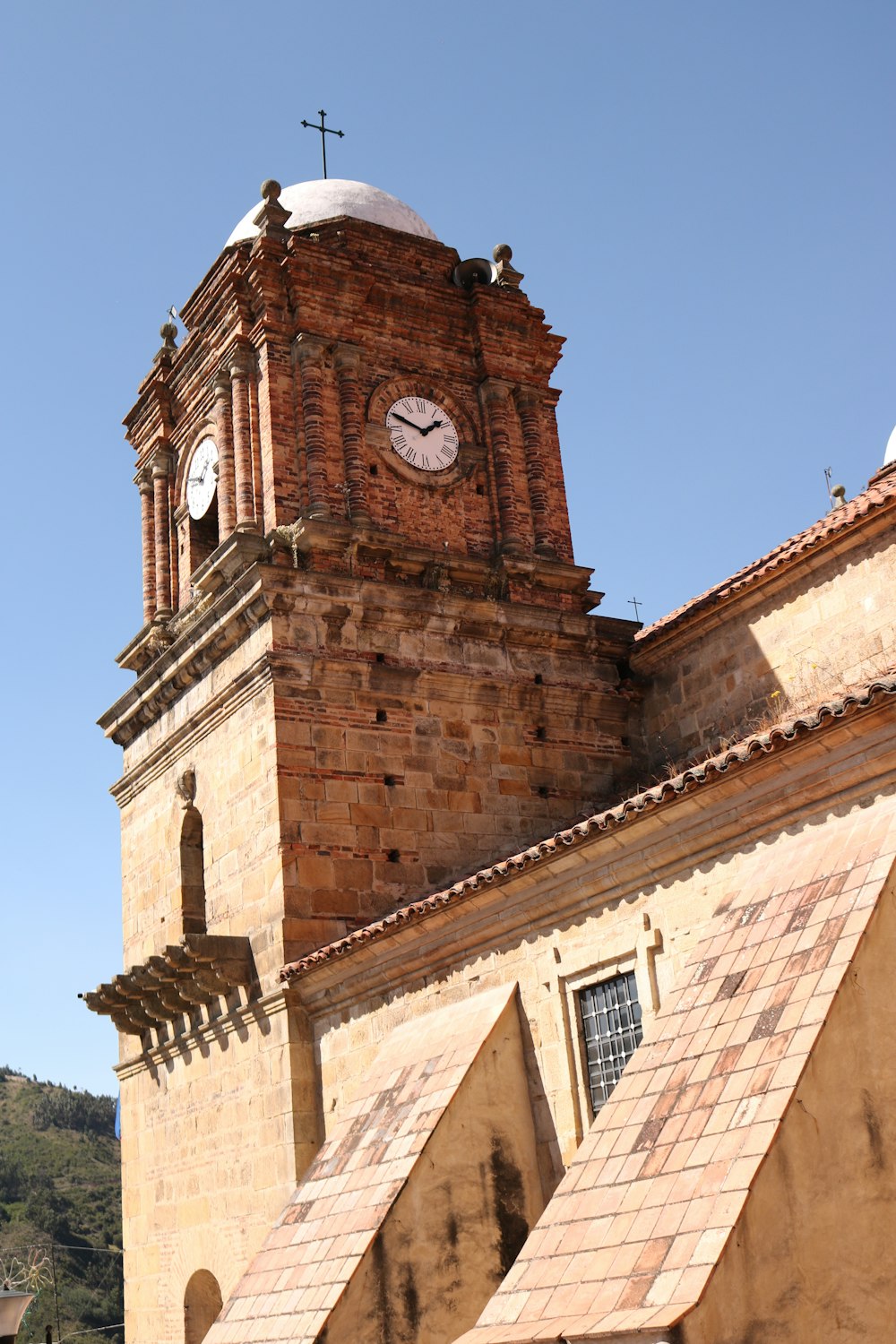 a clock tower with a cross on top of it