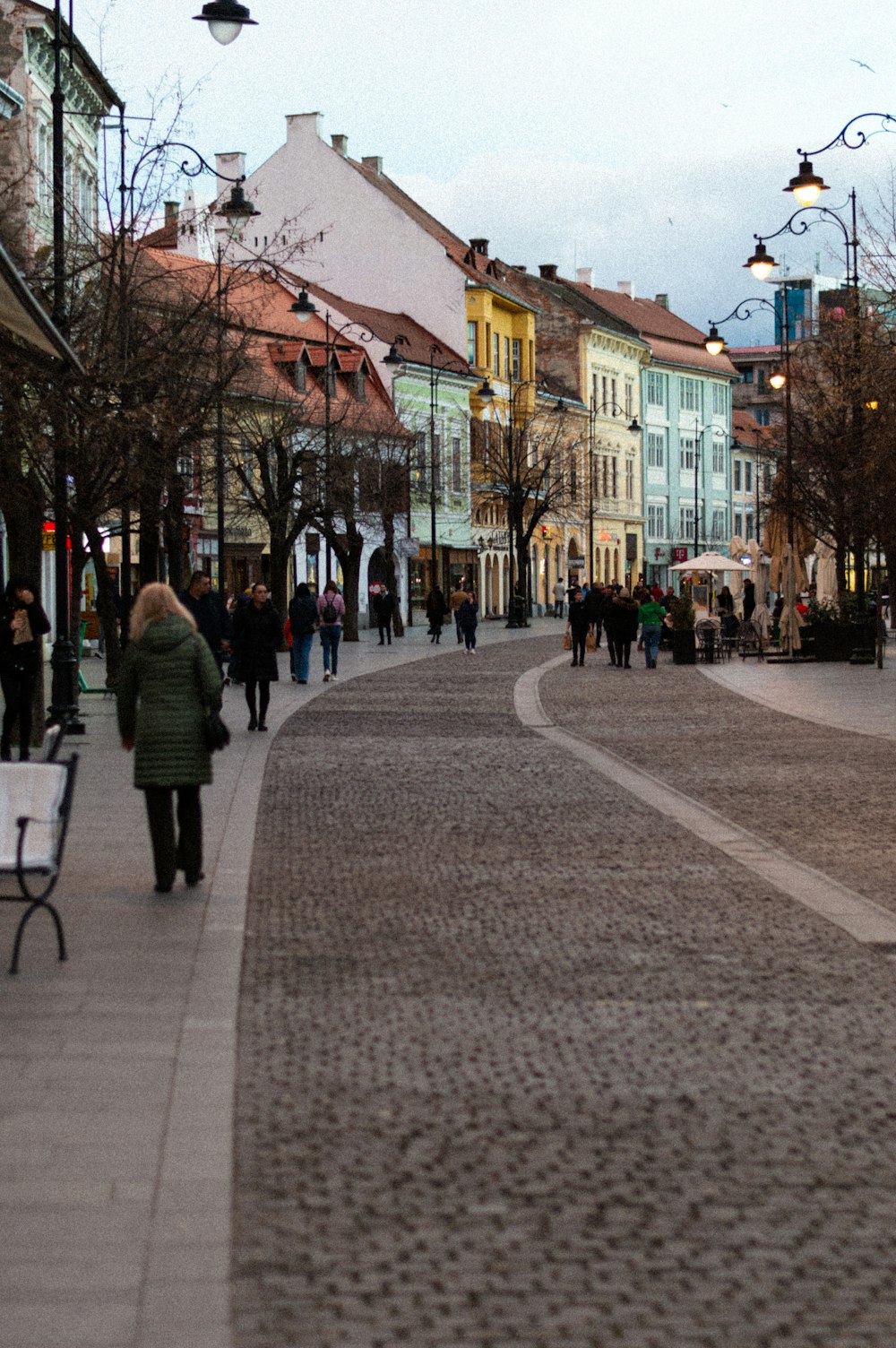 a group of people walking down a street next to tall buildings