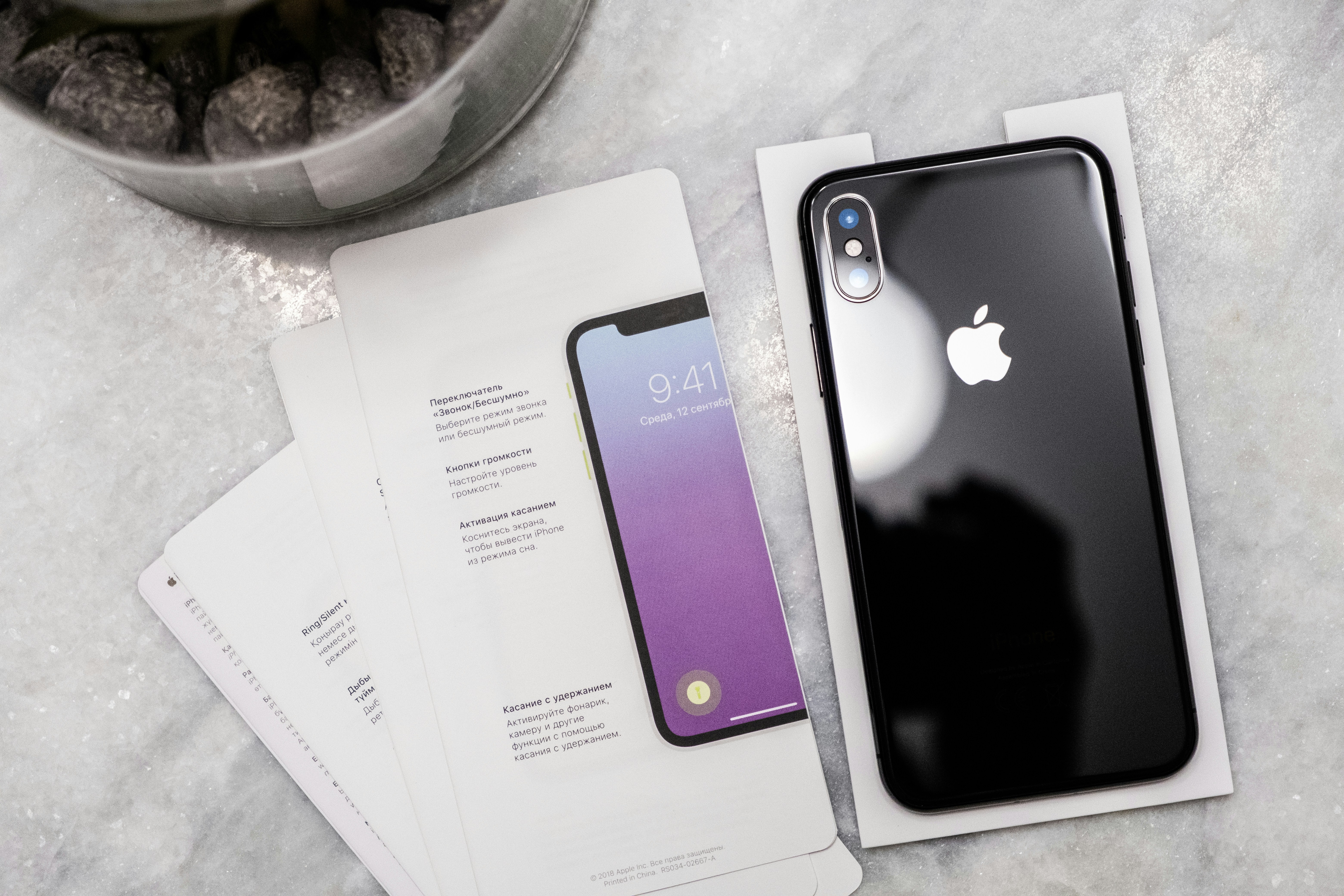 an iphone is sitting on a table next to some papers