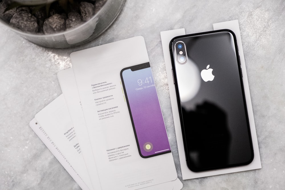 an iphone is sitting on a table next to some papers