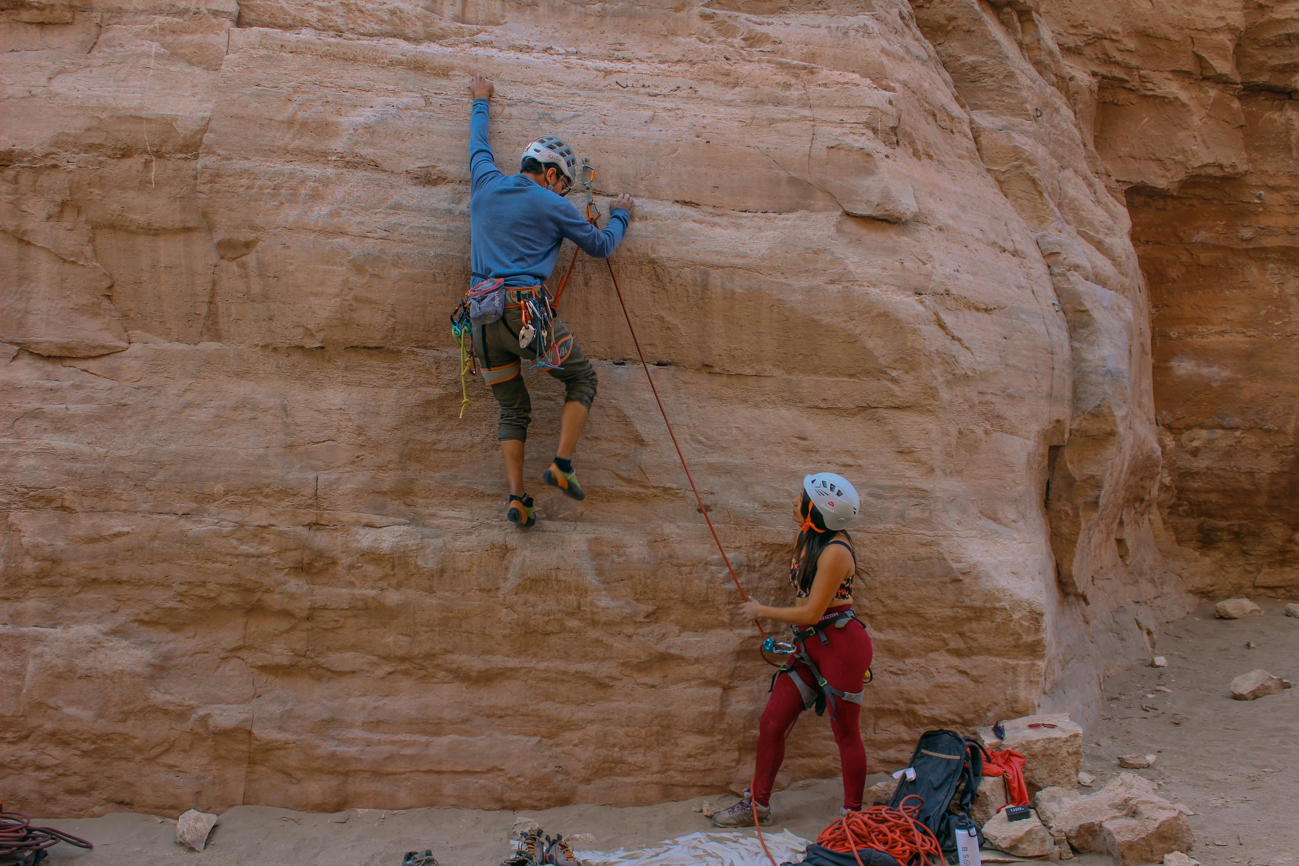 a man climbing up the side of a cliff