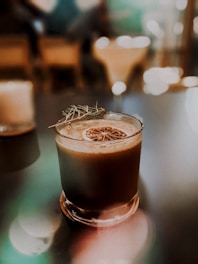 An artistic image of a glass of anis drink with a scenic background.