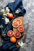 Close-up of bright dehydrated blood orange slices arranged on a rustic wooden board.