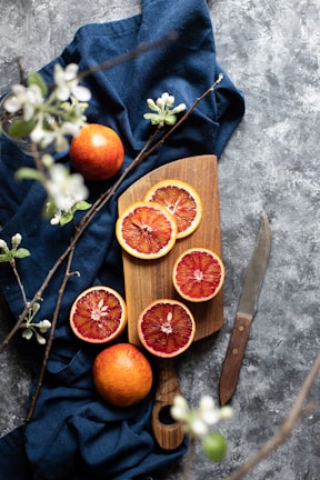 Close-up of bright dehydrated blood orange slices arranged on a rustic wooden board.