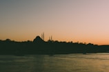 Serene mosque silhouette at sunset with soft golden light.