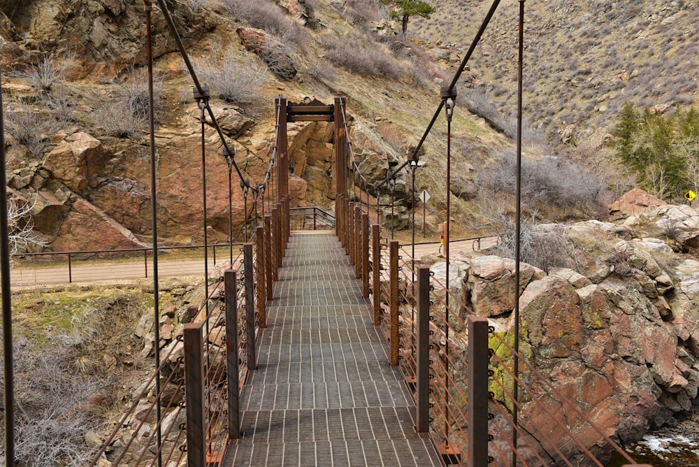a suspension bridge over a river in the mountains