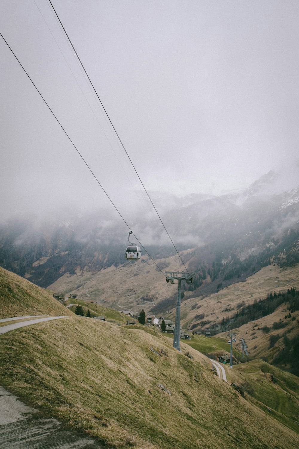 a ski lift going up a hill on a cloudy day
